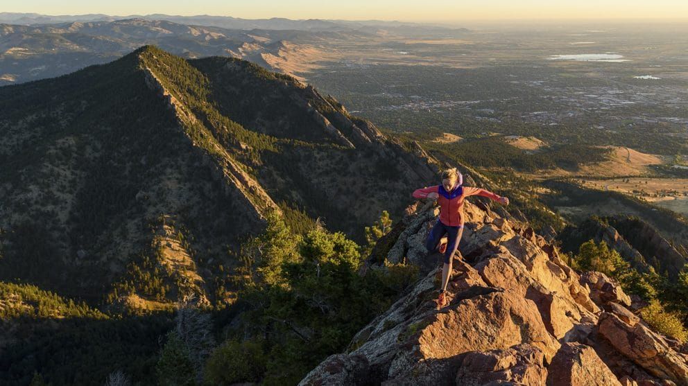 A photo of a woman mountain running on a ridge top