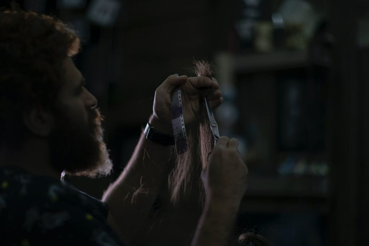 An individual cutting a lock of hair