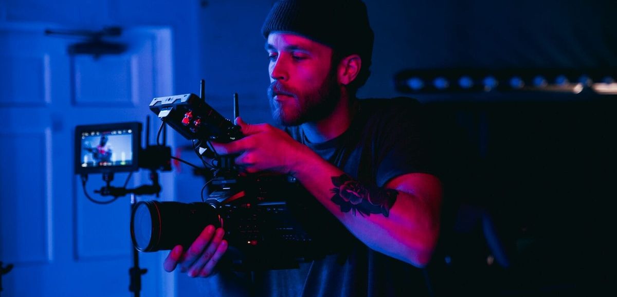 A man shooting in a dark-lit room