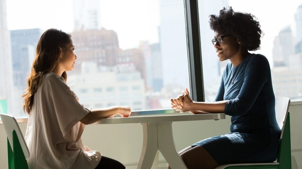 Two women seated talking to each other