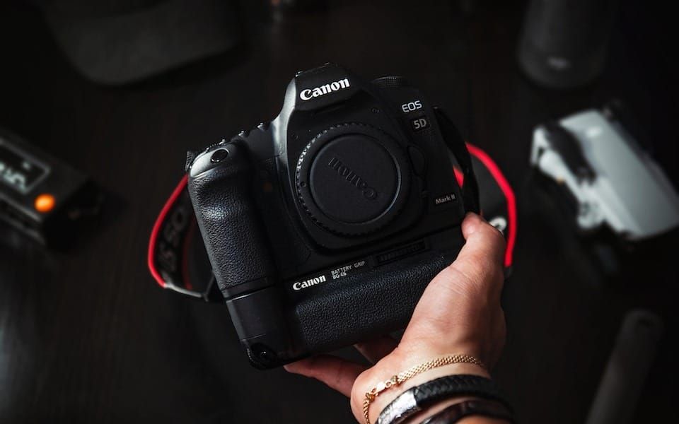 person holding black nikon dslr camera