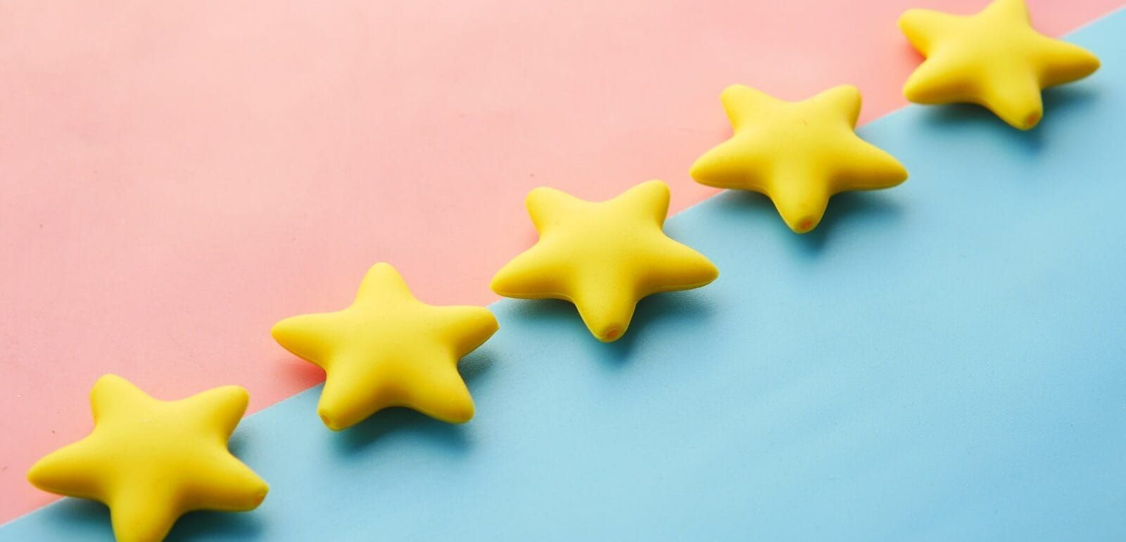 a row of yellow stars laid on top a blue and pink surface