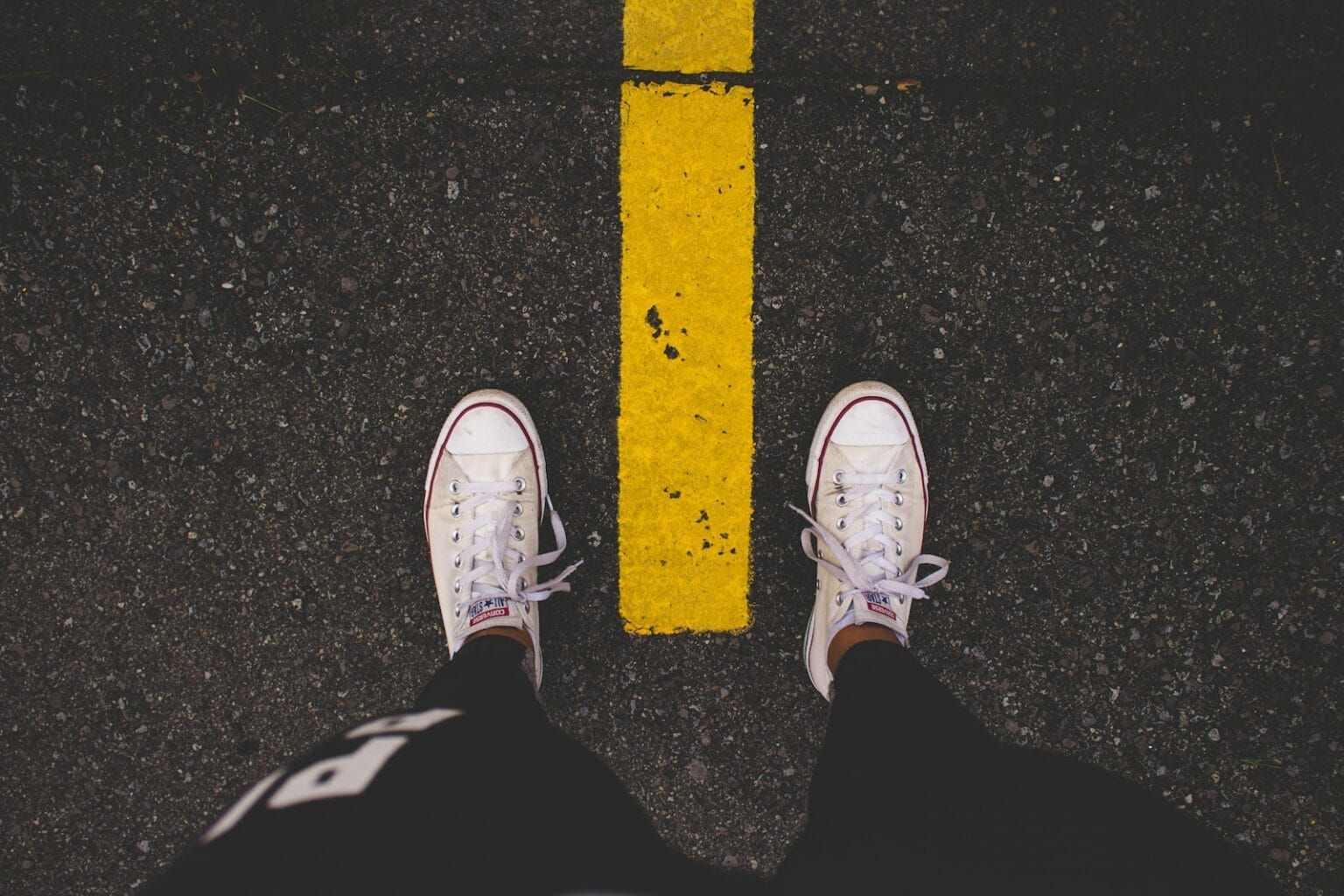 A shot of white Convese against the ground.