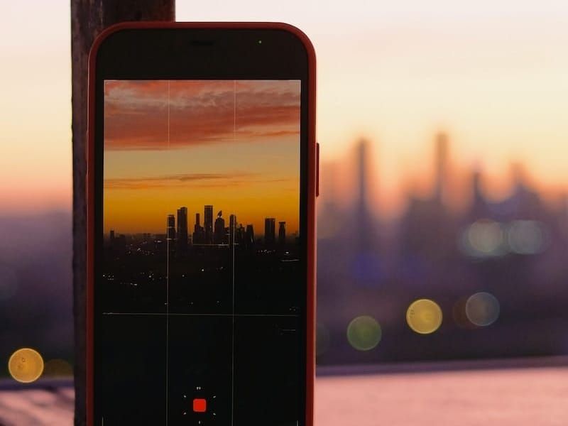 An iPhone pointed toward a city skyline