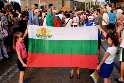 Деца държат българското знаме по време на протестите през 2013 г.