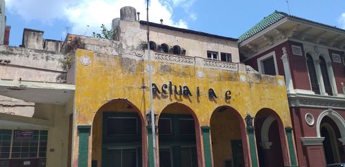 Сграда в Хавана с олющена фасада и надпис с липсващи букви