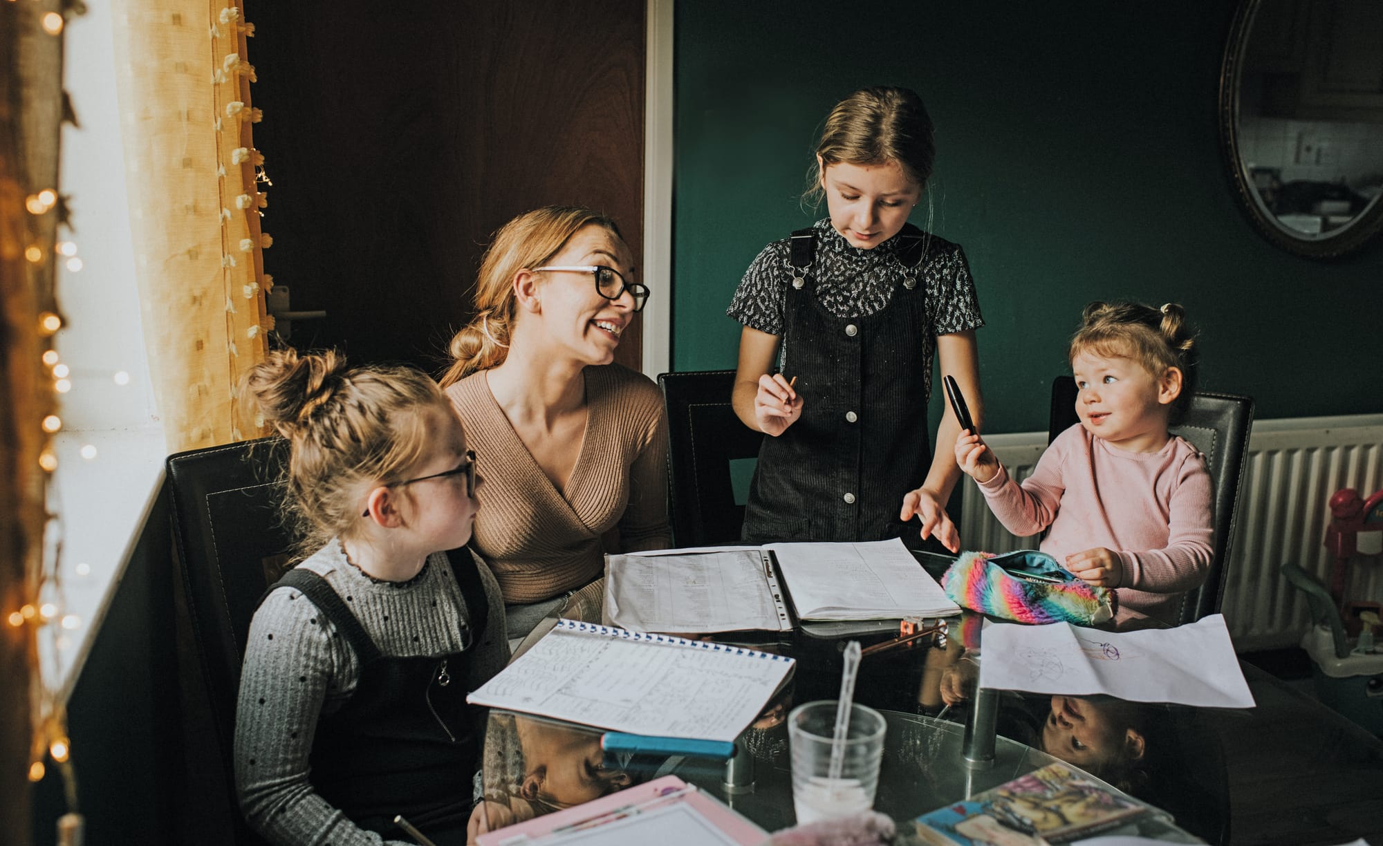 Photograph of a family gathered around a table planning together with notebooks and pens