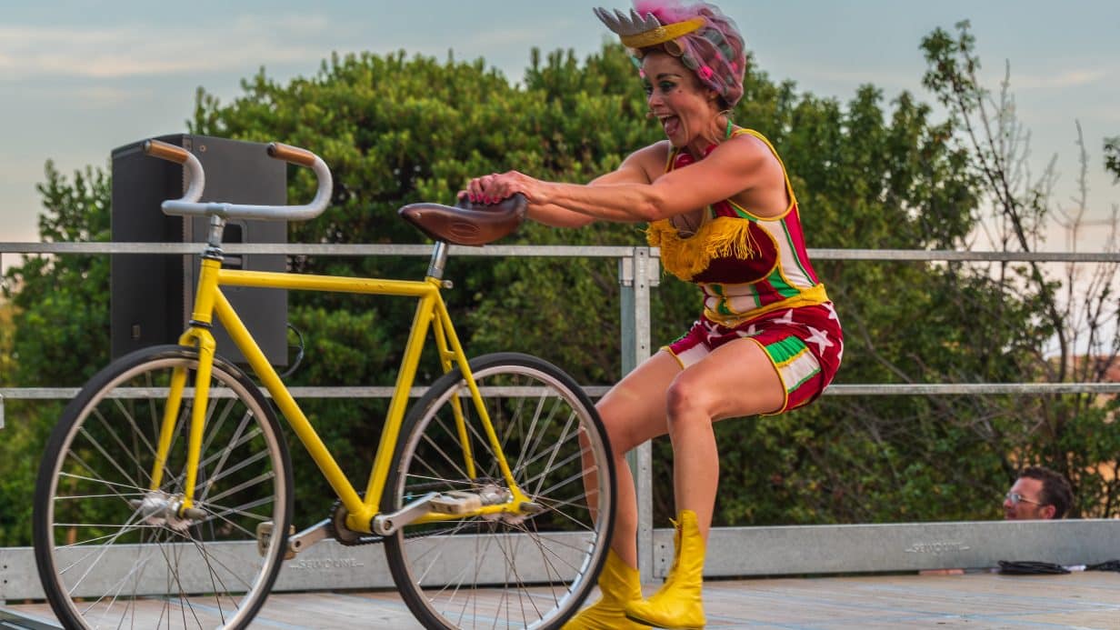 A woman hangs onto the back of a yellow bike