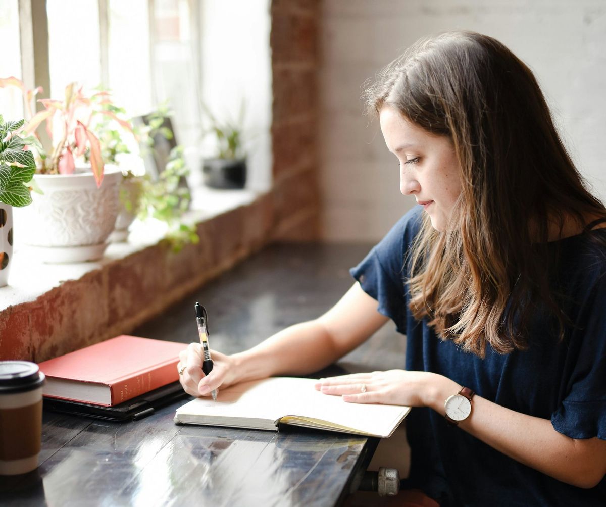 woman writing pen book