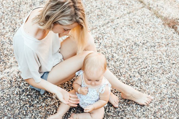 Photograph of a mother and her child sitting on the ground together