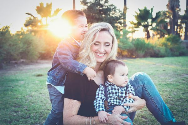 Photograph of a mother and her children in a natural setting with late evening sun shining on them