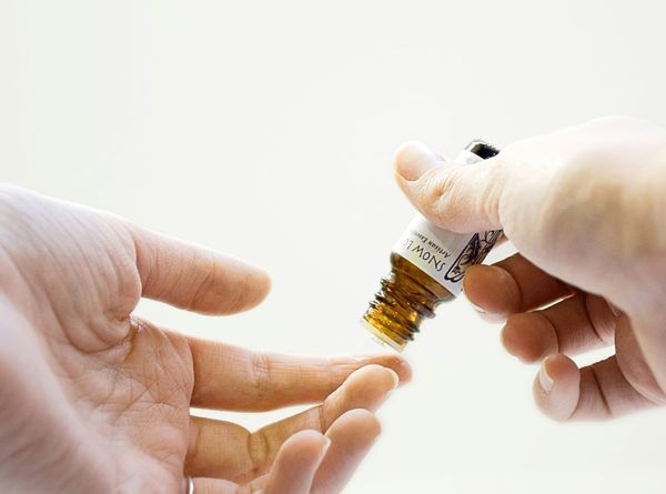 Photograph of hands holding an essential oil bottle