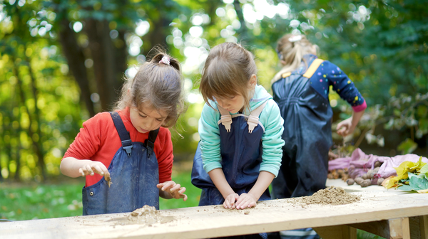 girls playing in mud kitchen
