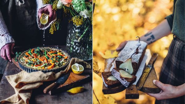 A sweet potato and chickpea quiche on a rustic table beside a pear and walnut loaf cake held against golden autumn leaves