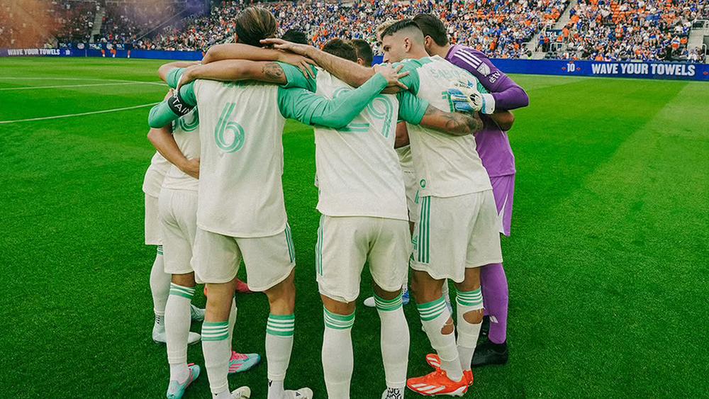 Austin FC players huddling on field before match with FC Cincinnati