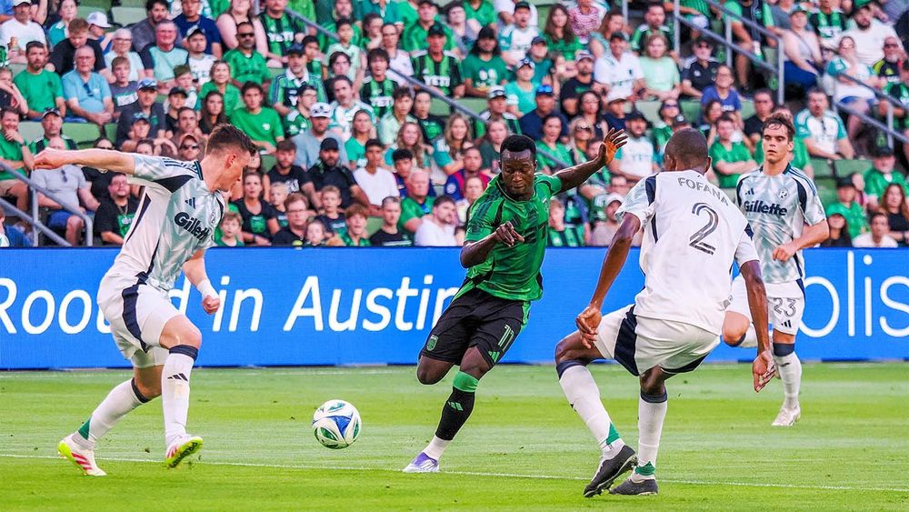 Osman Bukari in between two New England Revolution defenders