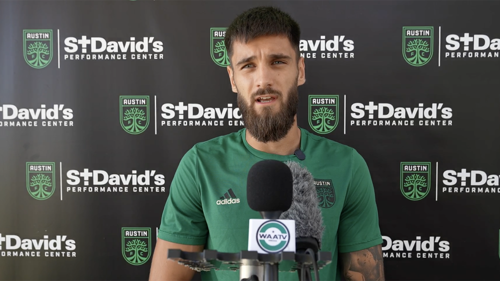 Mateja Đorđević in front of microphones speaking to Austin media