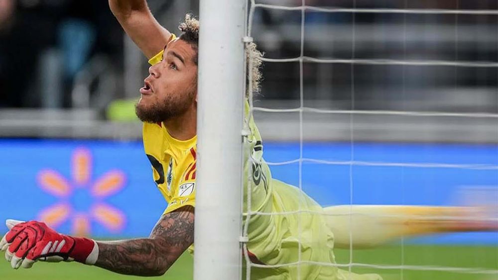 Minnesota goalkeeper Dayne St. Clair diving toward goal