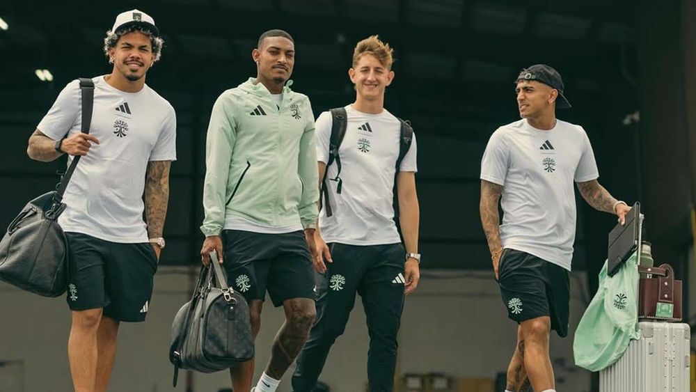 Austin FC players with travel bags readying to board a plane to Louisville