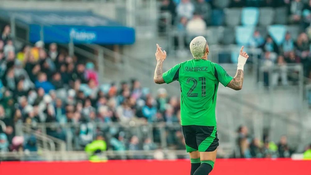 Austin FC's Christian Ramírez celebrates his equalizer against Minnesota United FC, pointing index fingers toward the sky