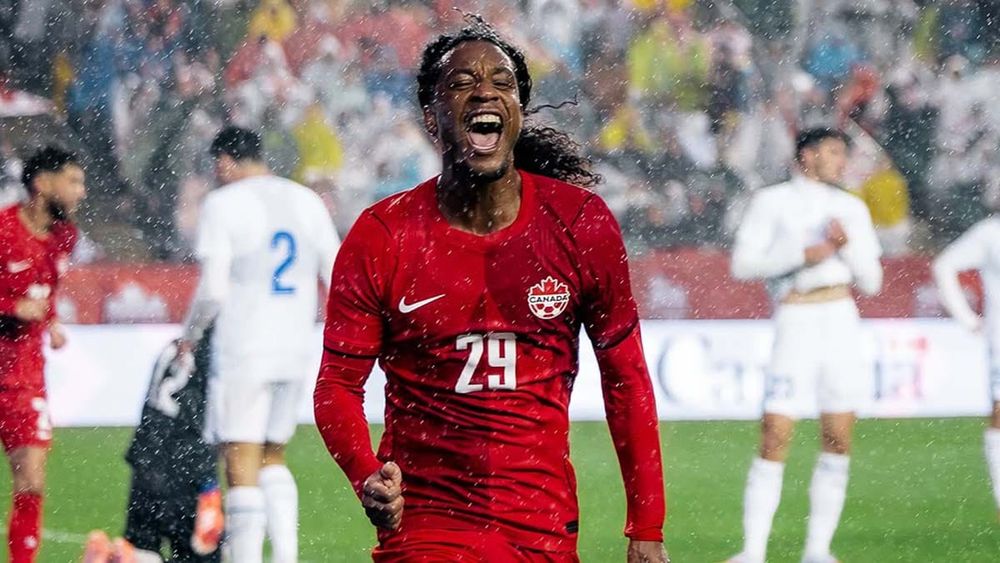 Jayden Nelson celebrates a goal in the rain after scoring for Canada against Uzbekistan