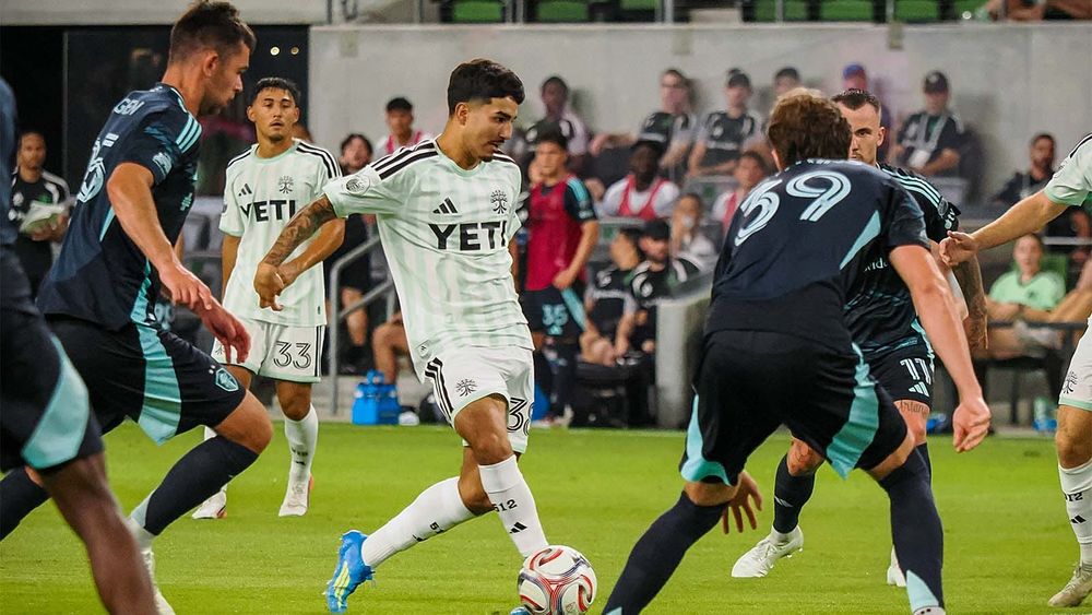 Austin FC's Ervin Torres, surrounded by Seattle Sounders players, about to pass the ball