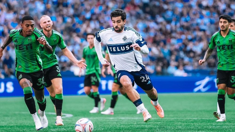 Vancouver's Brian White advancing the ball, surrounded by Austin FC defenders