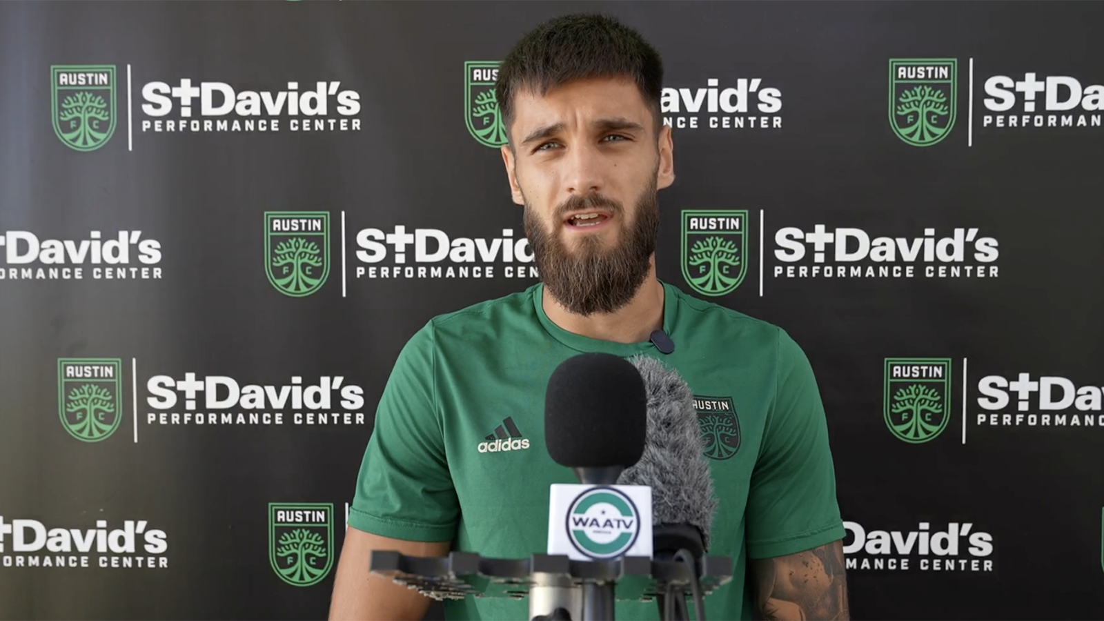 Mateja Đorđević in front of microphones speaking to Austin media