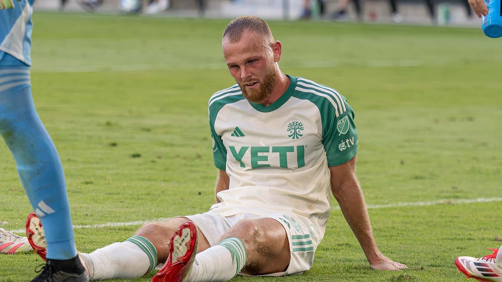 Mikkel Desler injured and sitting down on field during Austin FC match