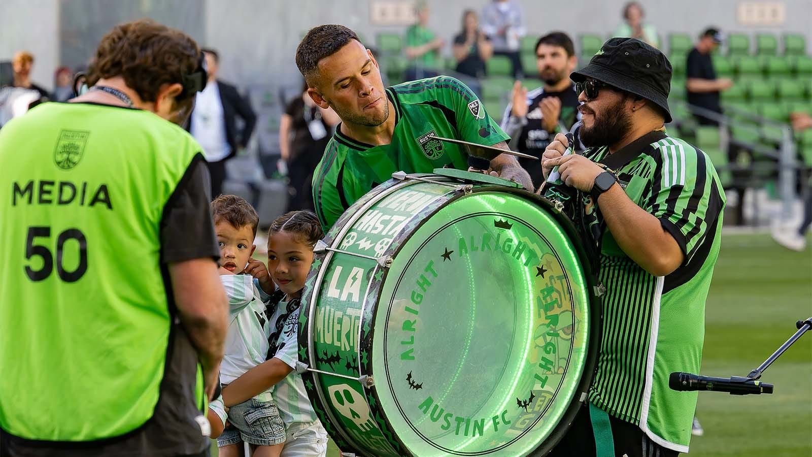 Christian Ramírez bangs the drum in the post-match ceremony following his Man of the Match performance