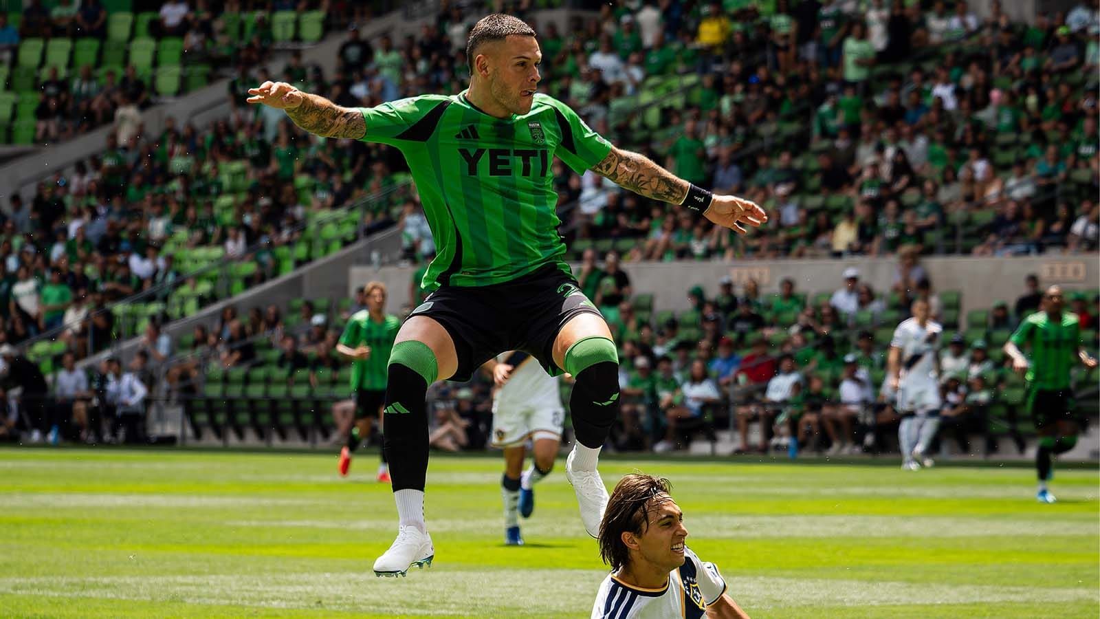 Christian Ramírez of Austin FC jumping over an LA Galaxy player