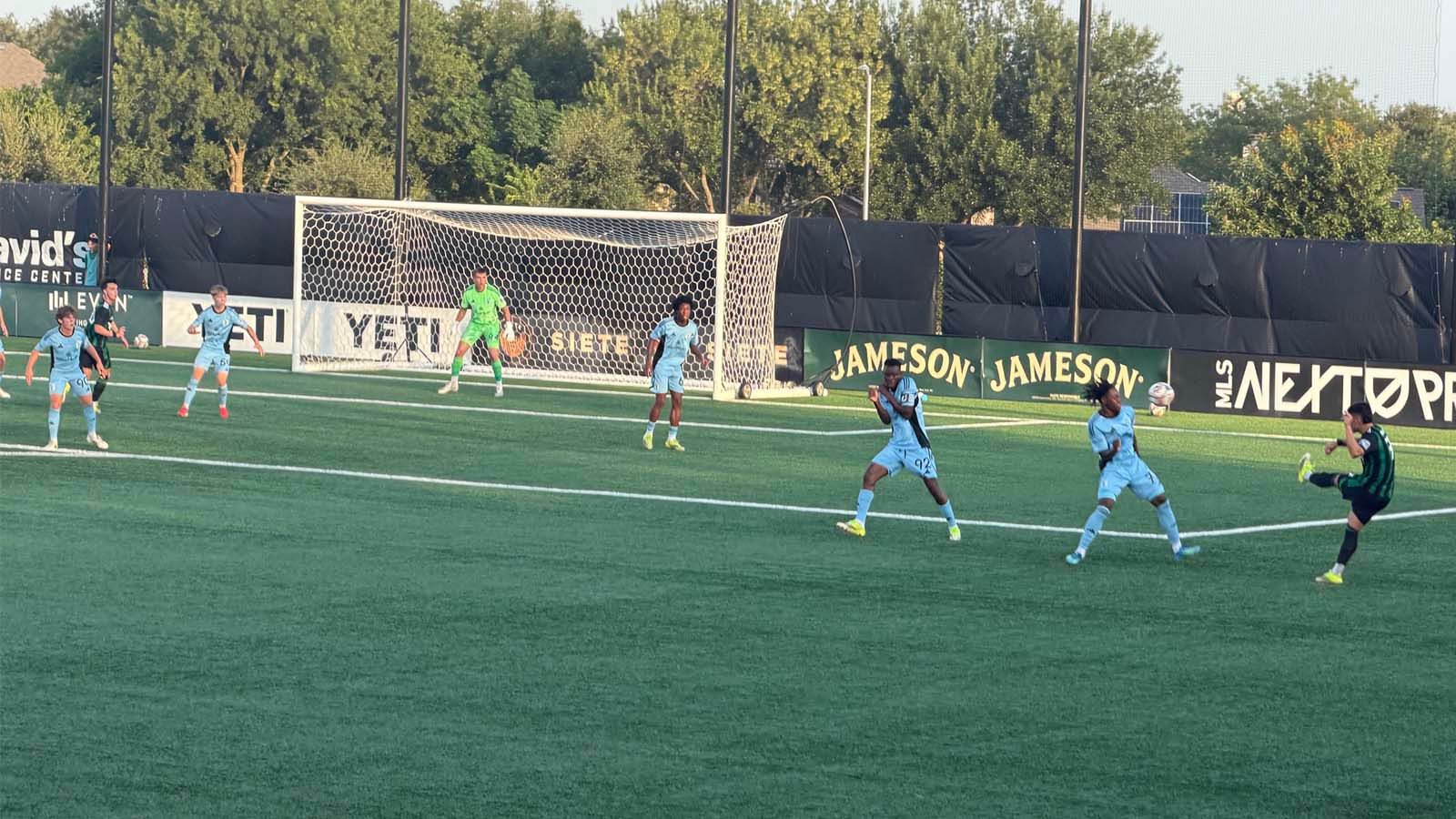 Austin FC II's Diego Abarca kicking a ball toward goal with Minnesota United FC 2 players defending goal