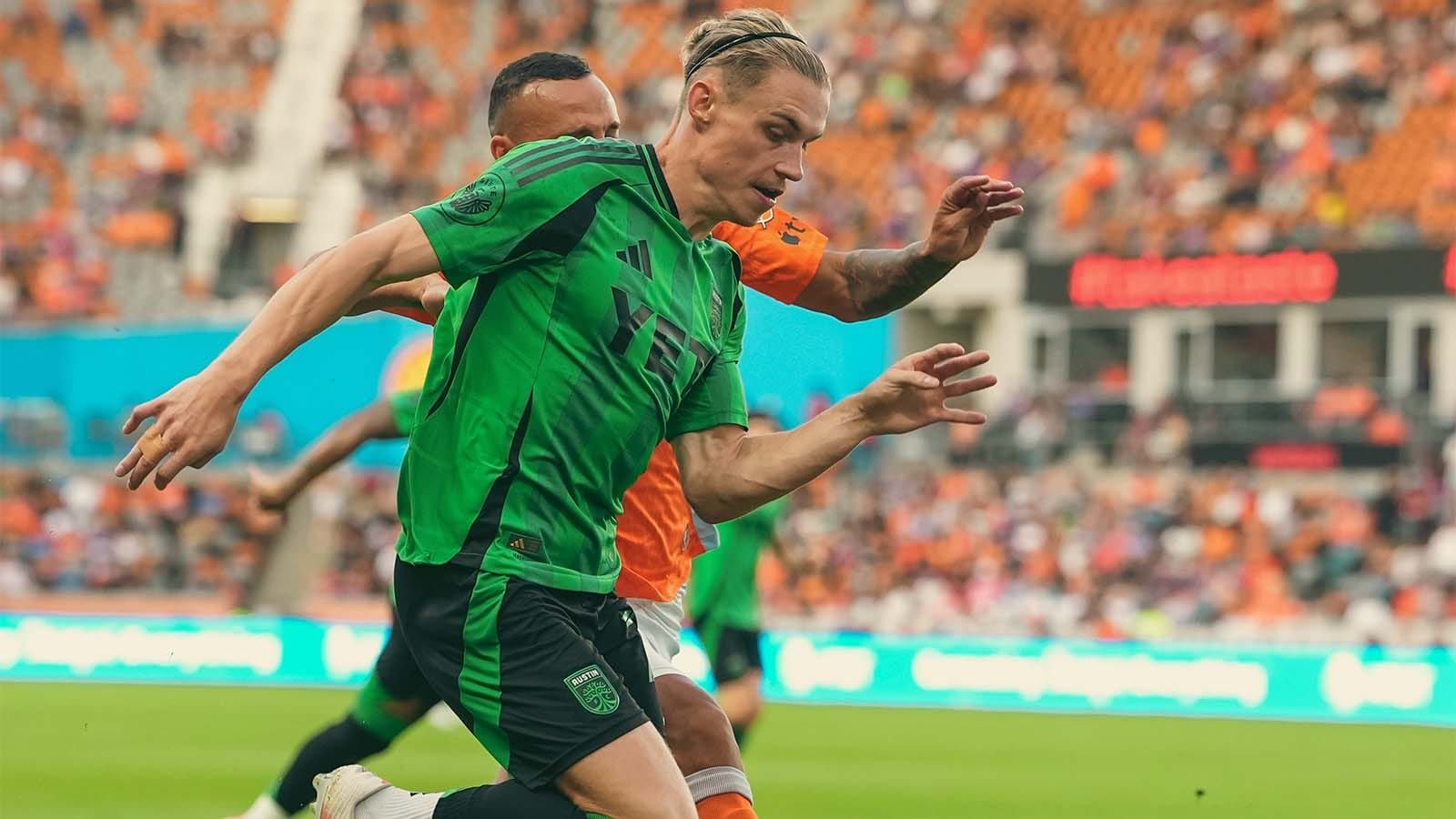 Austin FC's Przemysław Płacheta running with a Houston Dynamo defender alongside him