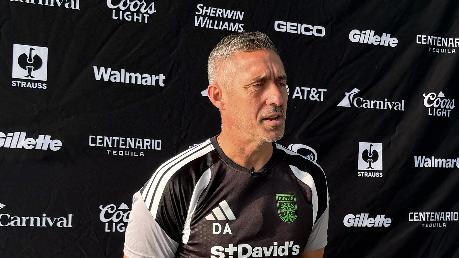 Austin FC head coach Davy Arnaud at a media availability for Leagues Cup (in front of a backdrop showing Leagues Cup sponsors