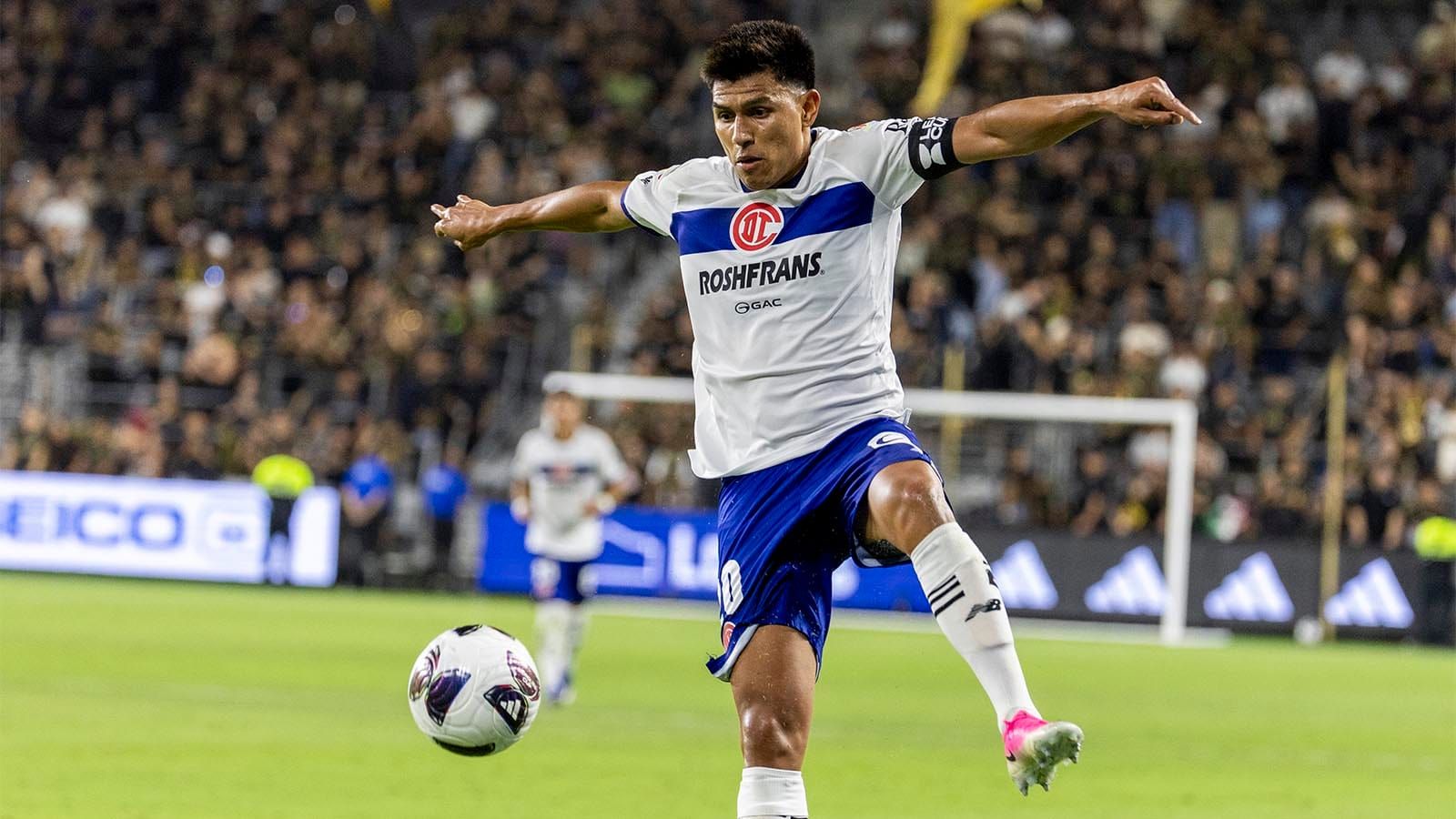 Toluca FC's Jesus Gallardo trying to stop a ball with arms spread wide and left foot raised