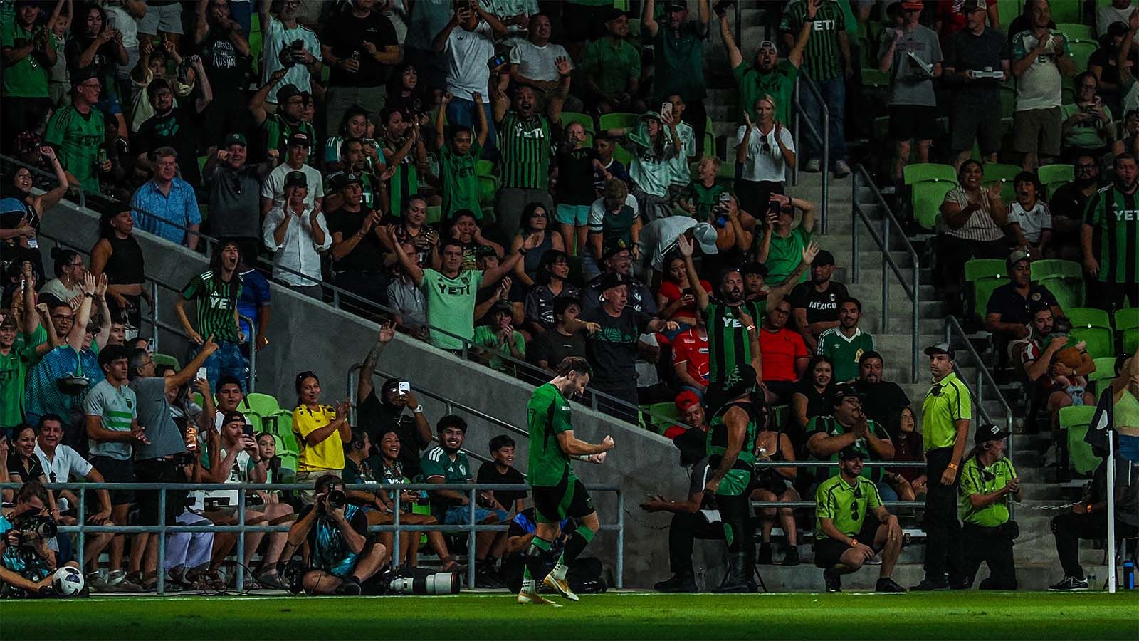 Austin FC's Jon Gallagher celebrates scoring a goal in front of cheering Austin FC fans (and blasé Mexican soccer fans)