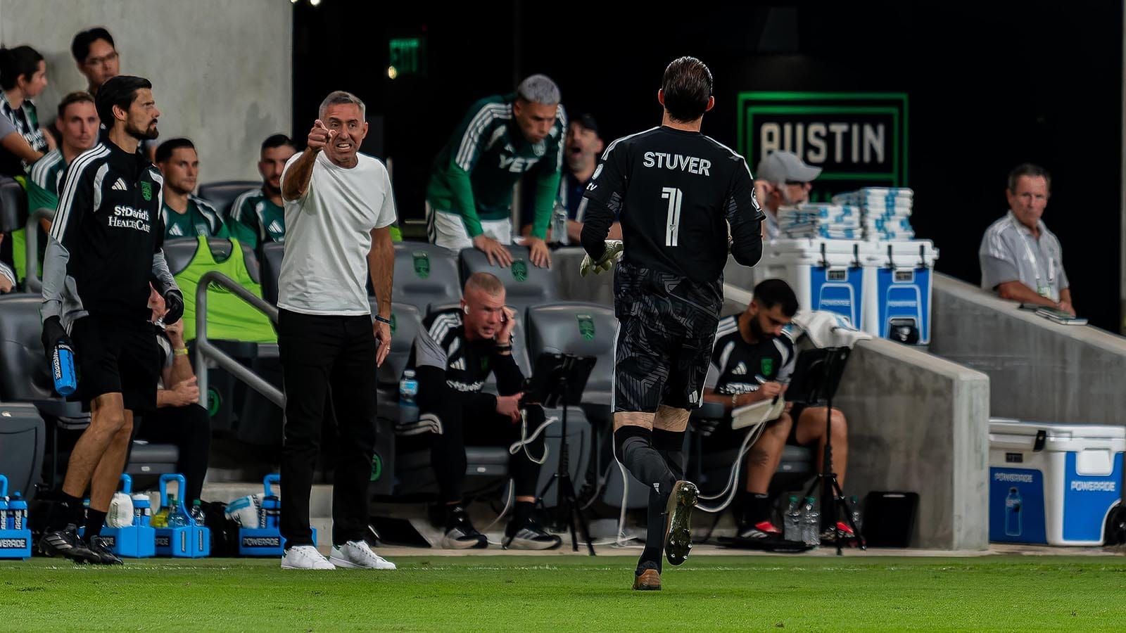 Austin FC interim head coach Davy Arnaud pointing and grimacing with Brad Stuver in the vicinity