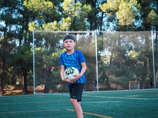 Niño con balón de fútbol base
