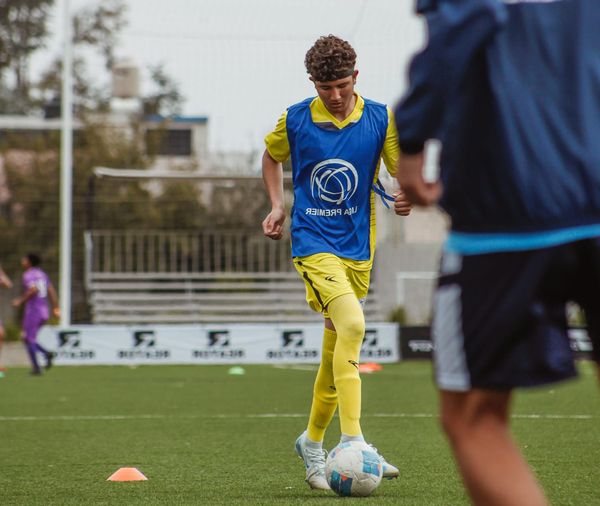 Jugador de fútbol realizando un ejercicio de calentamiento con balón