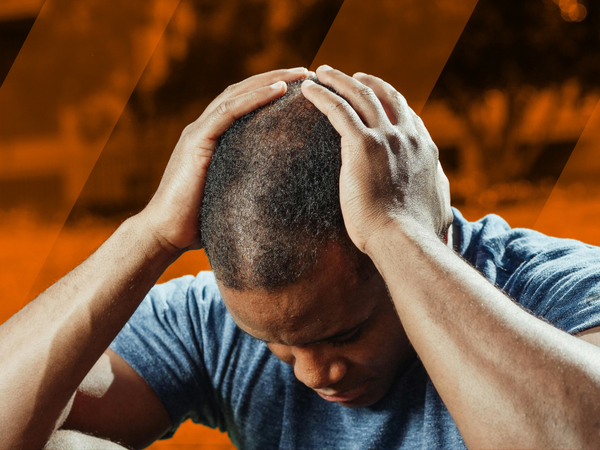 Futbolista sentado en el campo con dolor de cabeza después de jugar un partido de fútbol