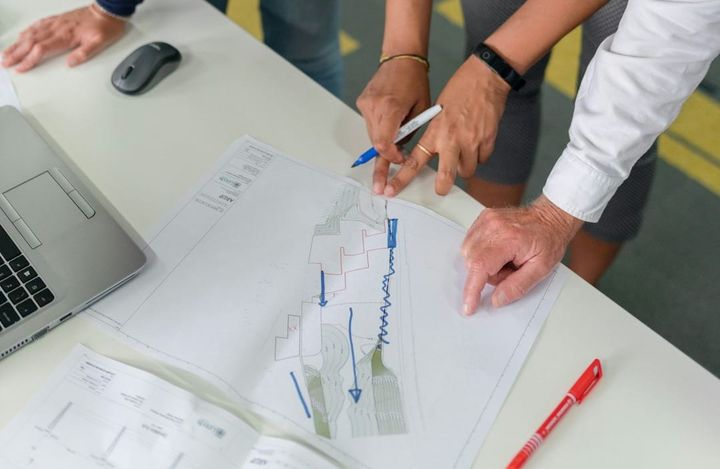 Small business owner consults with a tax advisor, discussing financial reports and federal income tax forms for strategic planning.