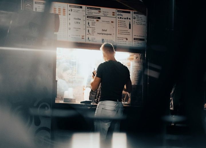 A small business owner studies a complex digital supply chain dashboard, symbolizing strategic operational planning and risk mitigation.
