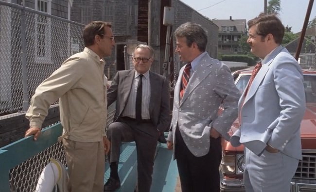 A screenshot of three men confronting Sheriff Brody