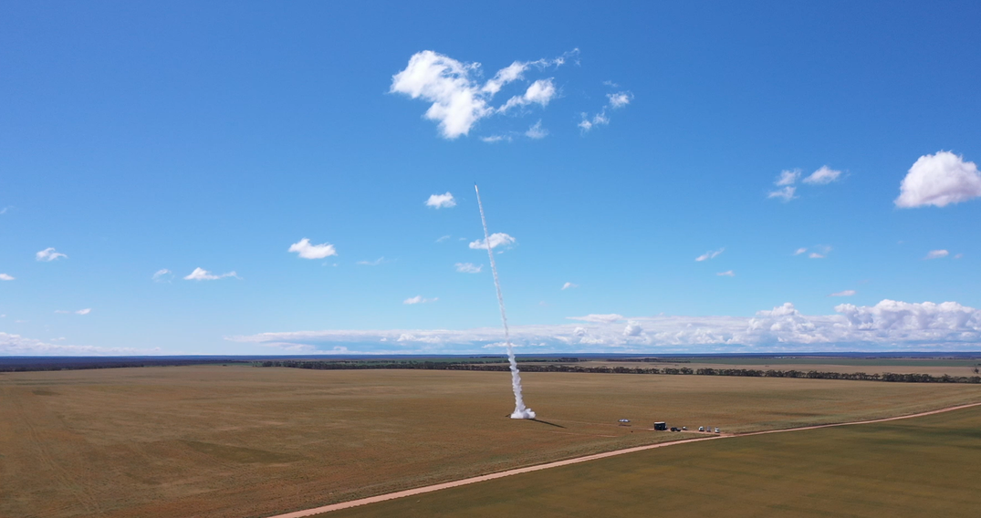 A rocket taking off from wide-open area in Australia during daytime
