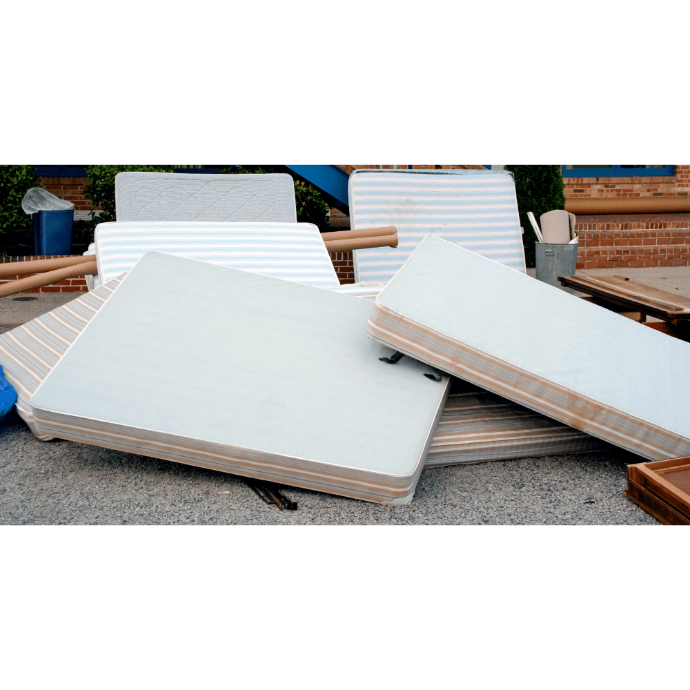 Pile of mattresses and bed parts prepared for junk removal