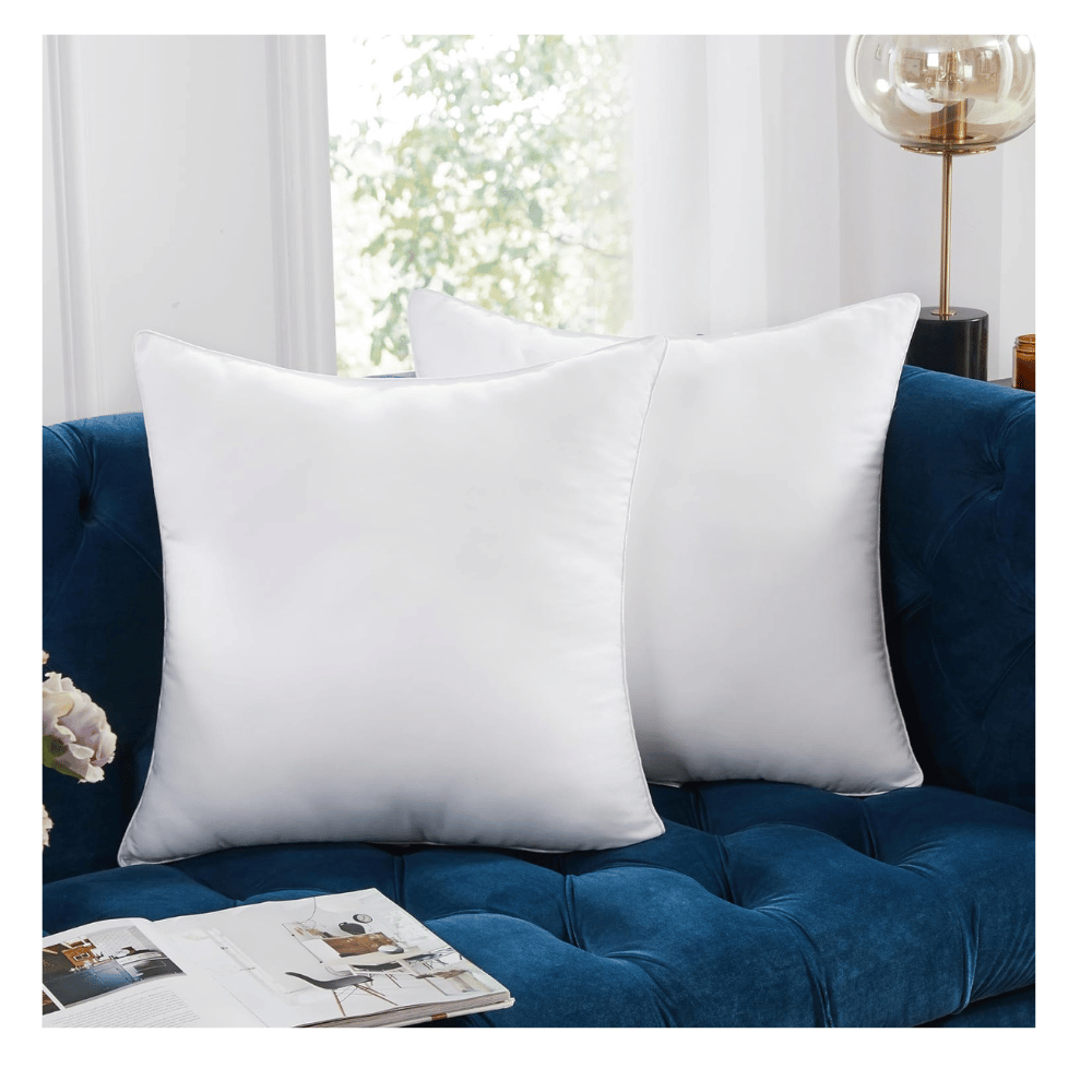 two white Deconovo pillow inserts on navy tufted sofa for modern living room décor (C: Deconovo/Amazon)