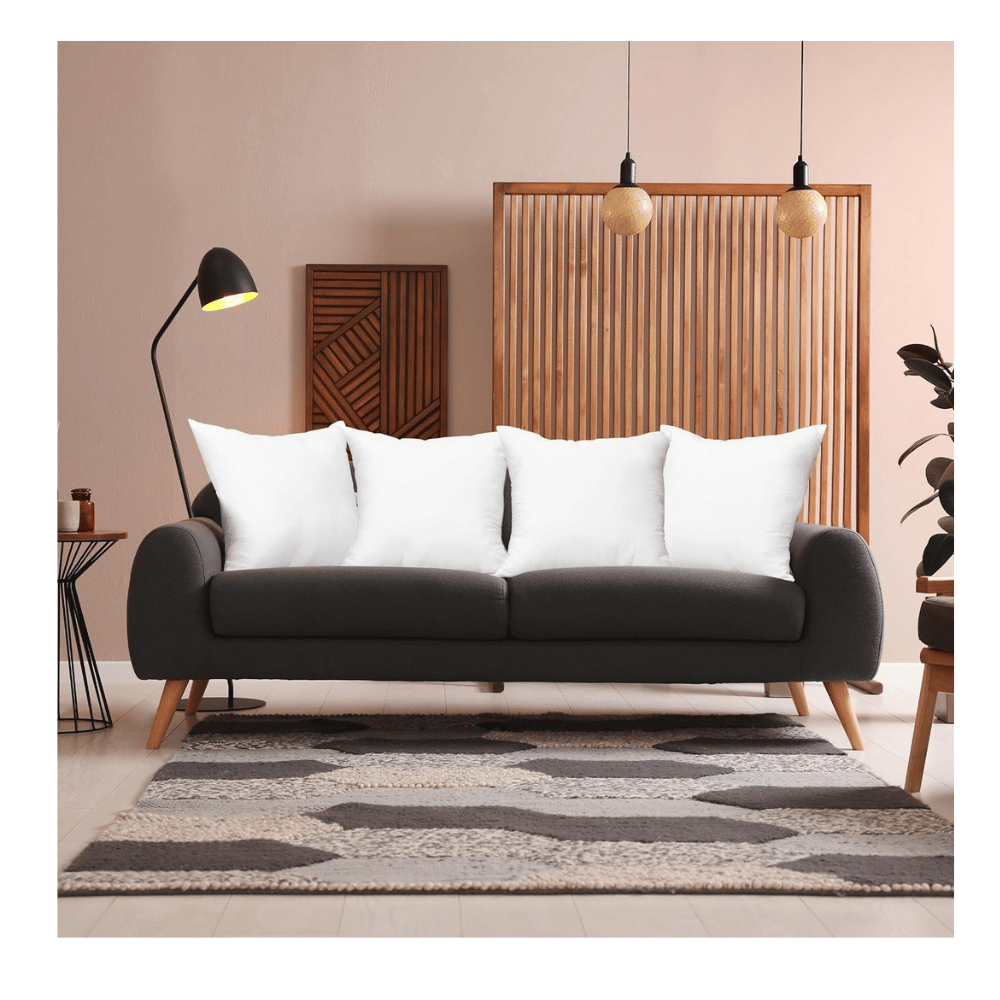 five white throw pillow inserts arranged across dark gray sofa for living room décor (C: Utopia Bedding/Amazon)