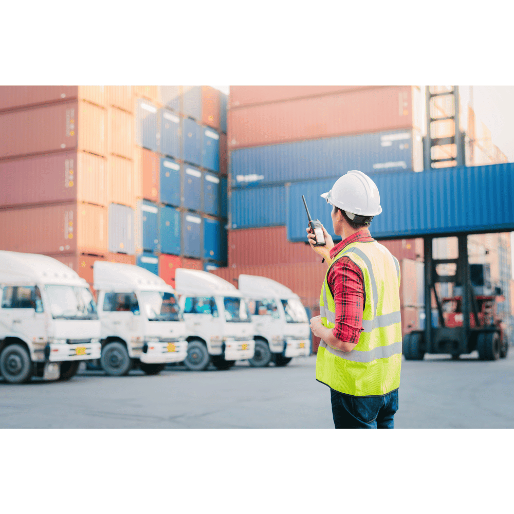 worker managing truck and container logistics at shipping warehouse