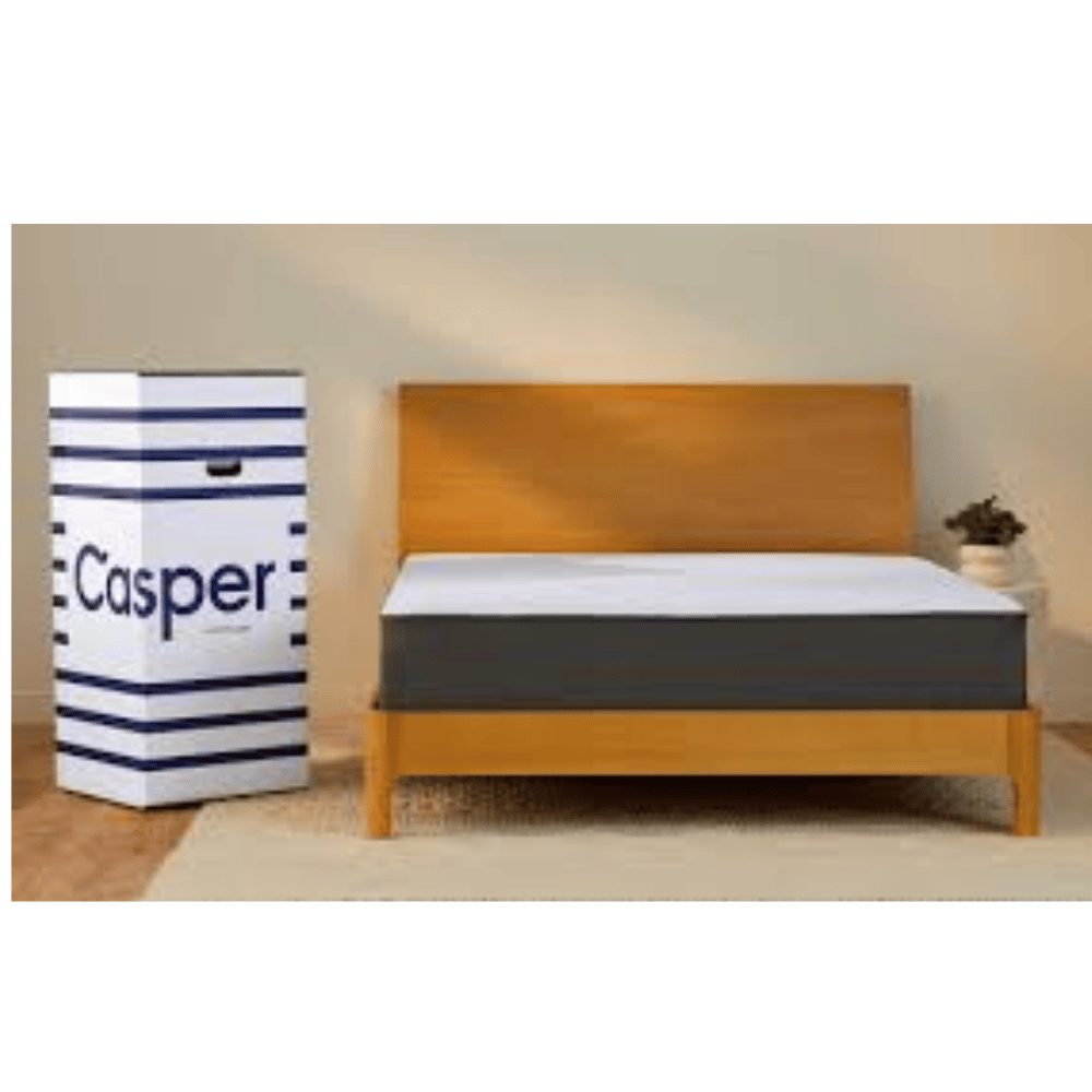 casper mattress in a box beside bed frame in warm lighting