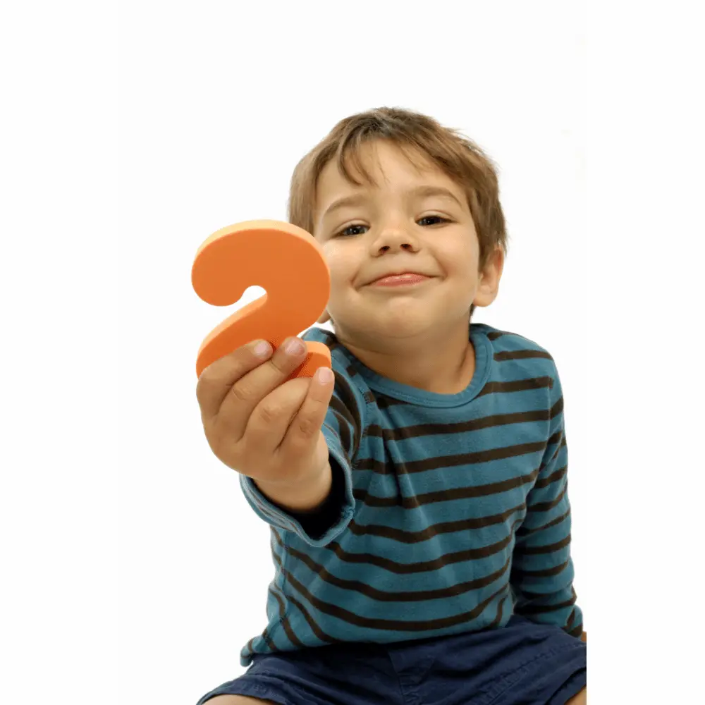 Smiling toddler holding number two